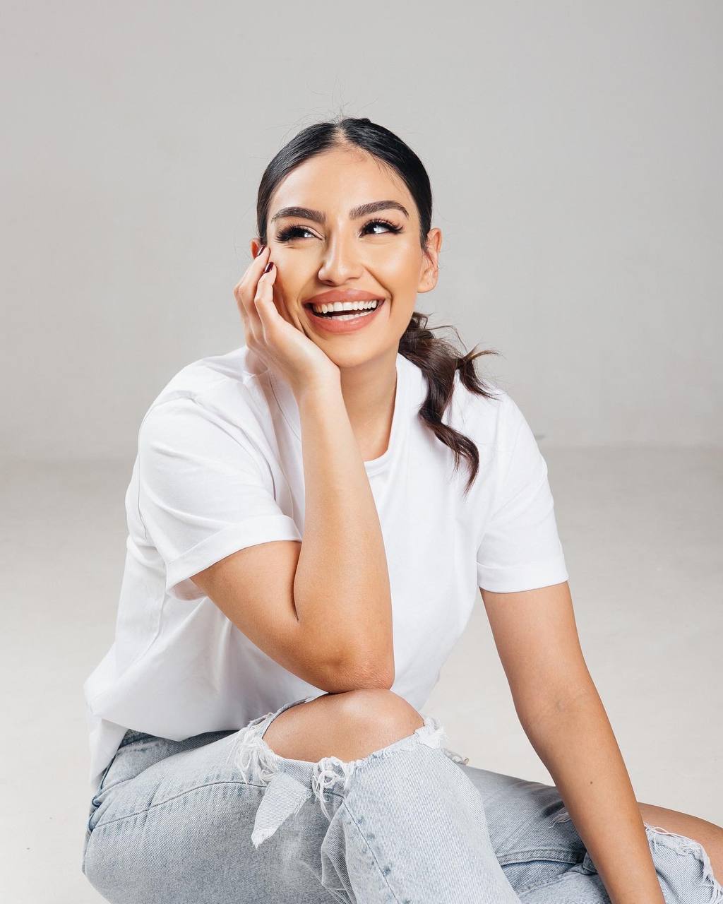 Nany smiling in a white shirt